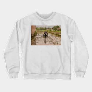 A man in backside view plows a village rice field. Crewneck Sweatshirt